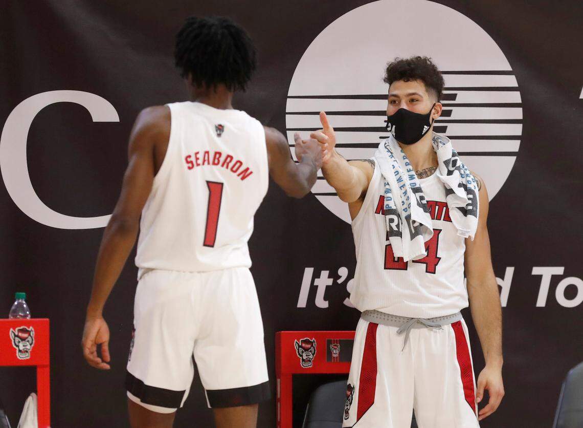 N.C. State’s Devon Daniels (24) congratulates Dereon Seabron (1) as he comes off the floor during the second half of N.C. State’s 95-61 victory over Charleston Southern in the Wolfpack Invitational at Reynolds Coliseum in Raleigh, N.C., Wednesday, Nov. 25, 2020.