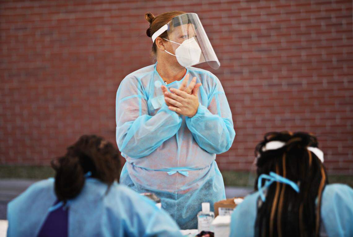 RN Tresa Webb sanitizes her hands before putting on a fresh pair of gloves between clients at a COVID-19 testing drive-thru for Advance Community Health in Raleigh on Thursday, Nov. 5, 2020. Advance Community Health hosts several free testing sites each week.