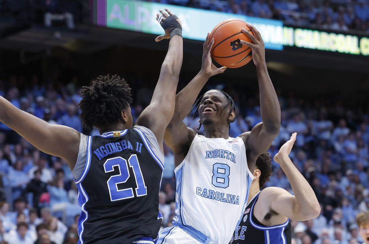 North Carolina's Caleb Wilson (8) shoots as Duke’s Patrick Ngongba II (21) and Cameron Boozer (12) defend during the first half of Duke’s game against UNC at the Dean E. Smith Center in Chapel Hill, N.C., Saturday, Feb. 7, 2026.