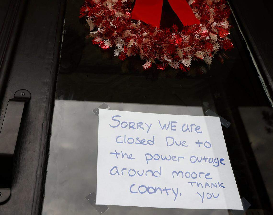 A sign on the door of Betsy’s Crepes alerts customers to its closure due to a power outage on Monday, Dec. 5, 2022, in Southern Pines, N.C.