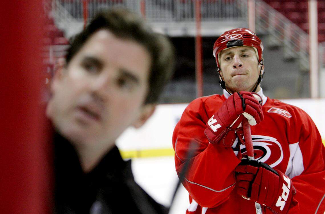 A 2006 photo shows Canes captain Rod Brind’Amour, right, looking on as head coach Peter Laviolette diagrams a play during practice.