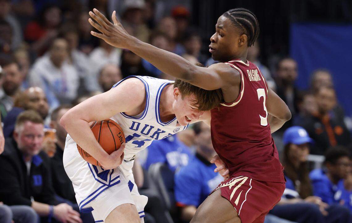 Florida State's Thomas Bassong (3) fouls Duke’s Nikolas Khamenia (14) during the first half of Duke’s game against Florida State in the quarterfinals of the 2026 ACC Men’s Basketball Tournament at the Spectrum Center in Charlotte, N.C., Thursday, March 12, 2026.