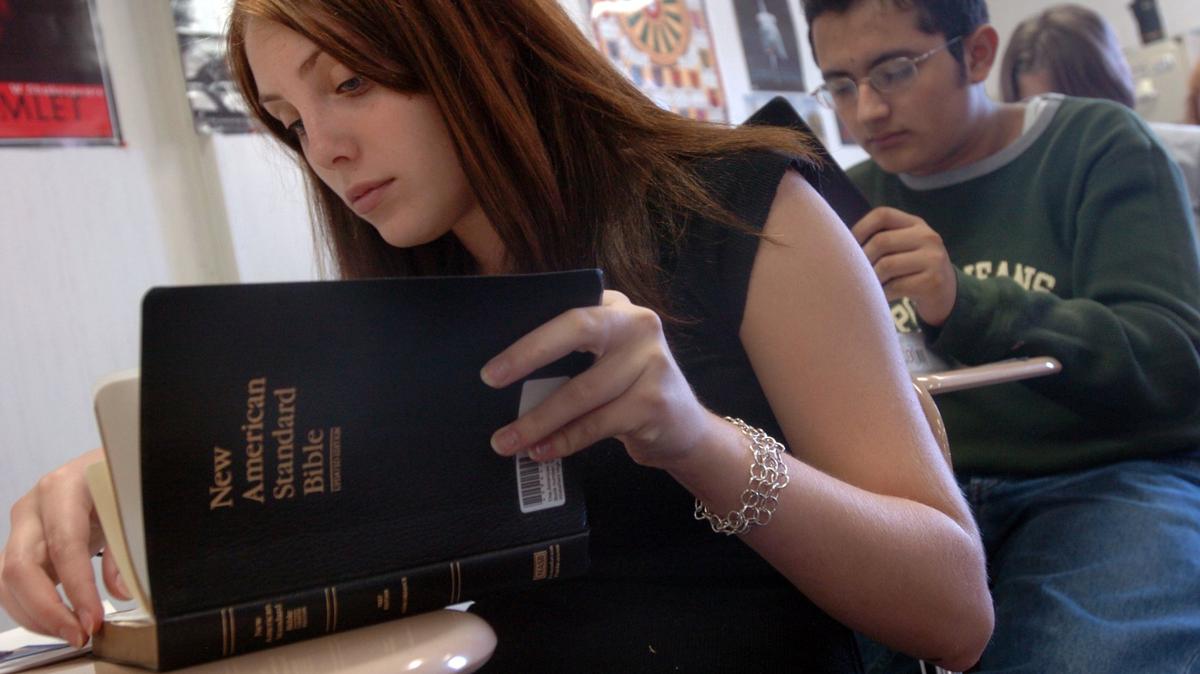 Nicole Herrell consults the New American Standard Bible during Barbara Travers’ Bible in History class at Wakefield High School in Raleigh in this 2005 file photo.