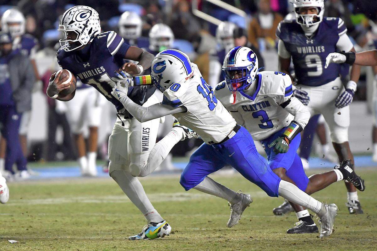 Grimsley quarterback Faizon Brandon (11) runs for the first down against Clayton's Charles Smith (10) during the first half.  The Clayton Comets and the Grimsley Whirlies met in the NCHSAA 7A football Championships in Chapel Hill, NC on December 12, 2025.