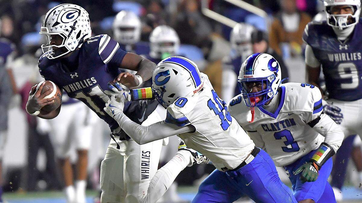 Grimsley quarterback Faizon Brandon (11) runs for the first down against Clayton's Charles Smith (10) during the first half.  The Clayton Comets and the Grimsley Whirlies met in the NCHSAA 7A football Championships in Chapel Hill, NC on December 12, 2025.