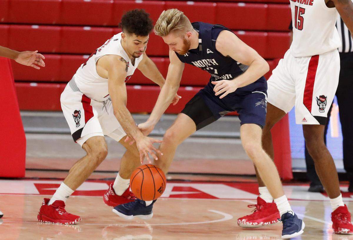 N.C. State’s Devon Daniels (24) fights for the ball with North Florida’s Josh Endicott (4) during the second half of N.C. State’s 86-51 victory over North Florida in the Mako Medical Wolfpack Invitational at Reynolds Coliseum in Raleigh, N.C., Friday, Nov. 27, 2020.