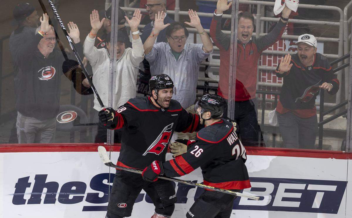 Carolina Hurricane left wing Jordan Martinook (48) celebrates with Sean Walker (26) after scoring the game winning goal in the second overtime to secure a 3-2 victory over Ottawa in Game 2 on Monday, April 20, 2026 during the first round of the Stanley Cup Playoffs at Lenovo Center in Raleigh, N.C.