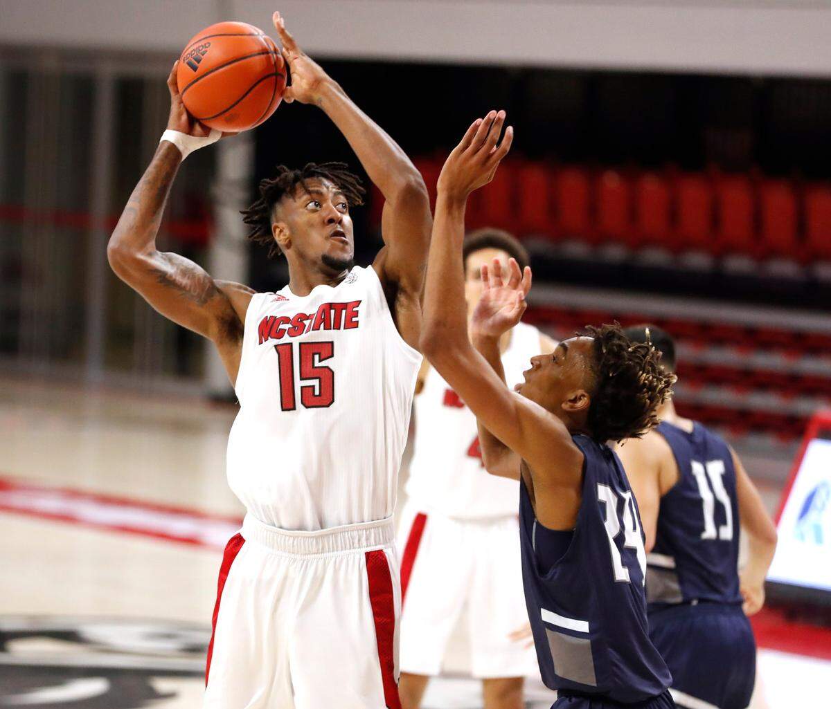 N.C. State’s Manny Bates (15) shoots as North Florida’s Jadyn Parker (24) defends during the second half of N.C. State’s 86-51 victory over North Florida in the Mako Medical Wolfpack Invitational at Reynolds Coliseum in Raleigh, N.C., Friday, Nov. 27, 2020.