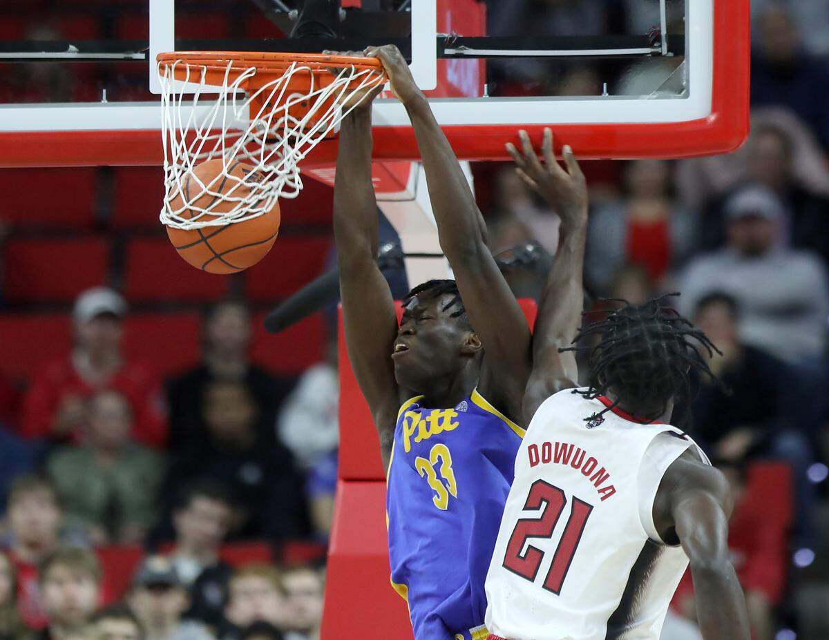 Pitt’s Federiko Federiko dunks over N.C. State’s Ebenezer Dowuona during the first half of a men’s basketball game at PNC Arena on Friday, Dec. 2, 2022, in Raleigh, N.C.