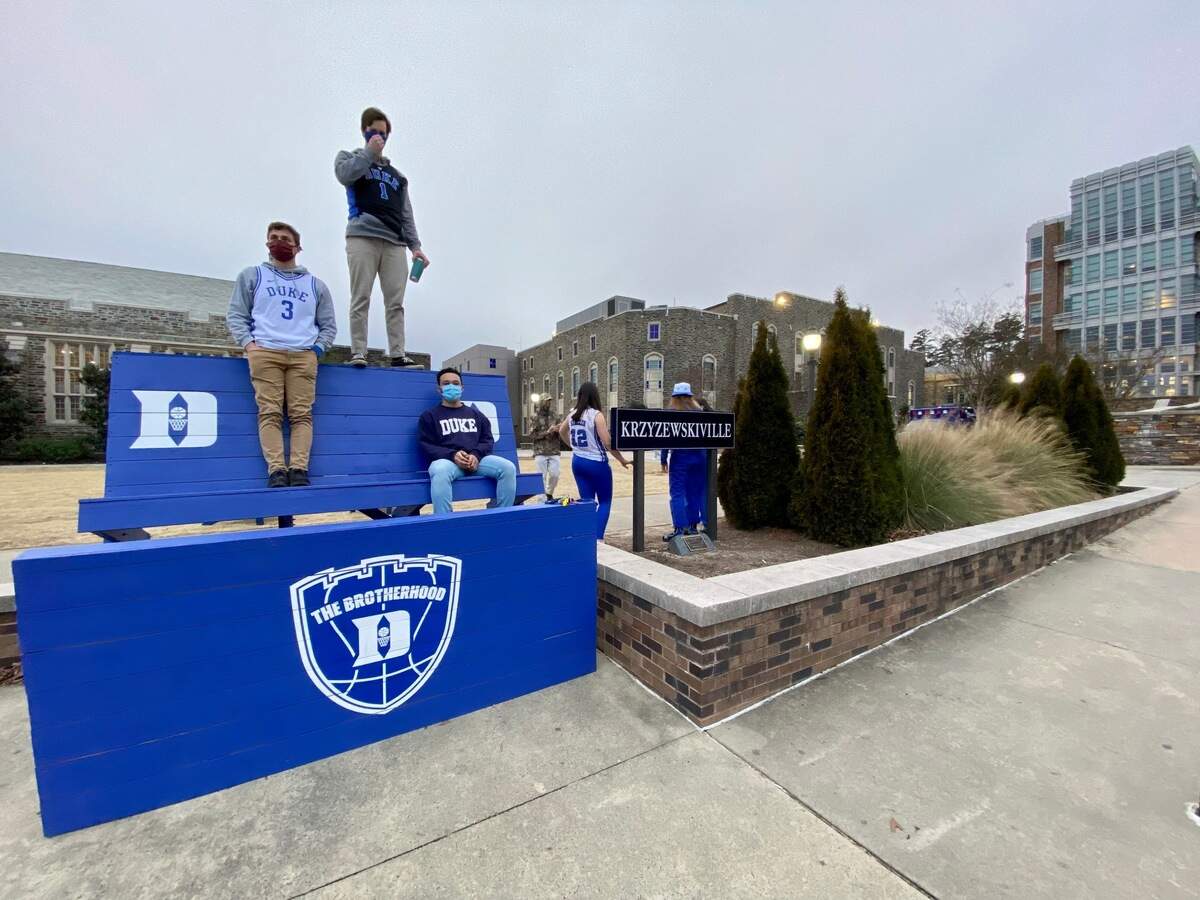 Duke senior Connor Penny (standing on top of bench) takes in the scene with his friends at an empty Krzyzewskiville before the start of Duke’s game against North Carolina on Saturday night, Feb. 6, 2021. Normally the area would’ve been crowded with students but not this year, during the pandemic.