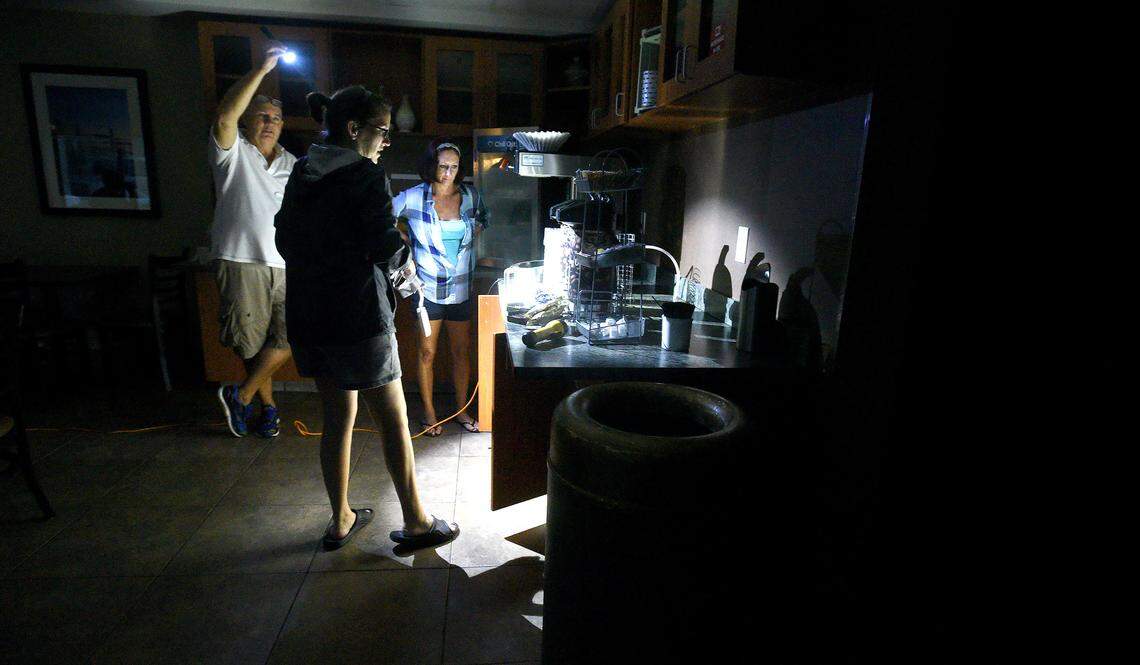 Mitchell Floor (left) holds a flashlight as Comfort Suites general manager Beth Bratz (center) and employee Dee Branch go to make coffee as Hurricane Florence rages in Wilmington, N.C. Friday, Sept. 14, 2018.  The area lost power around 4 a.m. and the facility was  running small lights, phone chargers and the coffee machine on a generator.