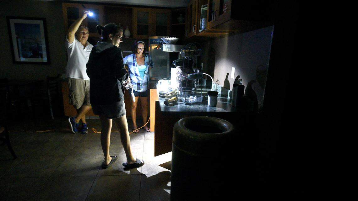 Mitchell Floor (left) holds a flashlight as Comfort Suites general manager Beth Bratz (center) and employee Dee Branch go to make coffee as Hurricane Florence rages in Wilmington, N.C. Friday, Sept. 14, 2018.  The area lost power around 4 a.m. and the facility was  running small lights, phone chargers and the coffee machine on a generator.