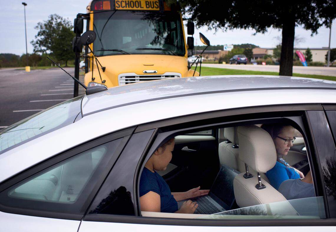 Students do online schoolwork using a “WiFi Bus” parked at a grocery store lot in Lumberton, N.C., Oct. 28, 2020. Millions of American students are grappling with the challenge of learning remotely without adequate home internet service, particularly in poorer locales like Robeson County.