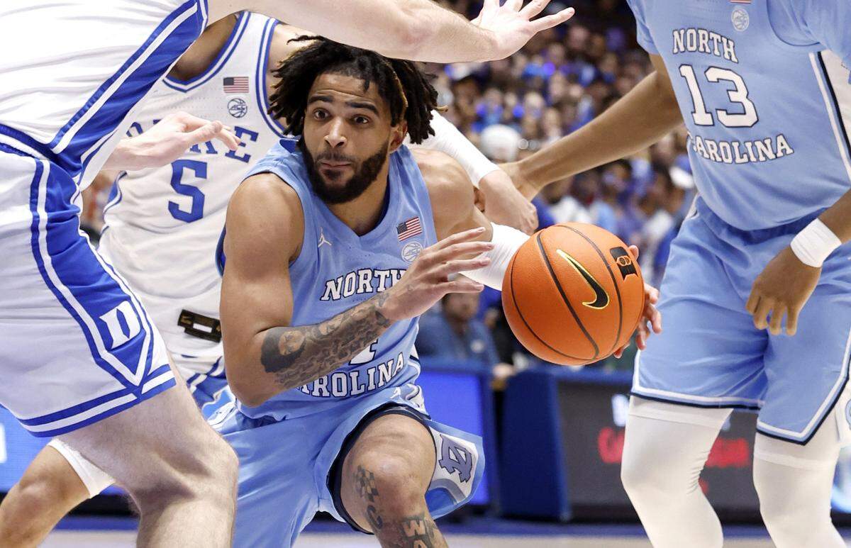 North Carolina’s RJ Davis (4) drives past Duke’s Tyrese Proctor (5) and Ryan Young (15) during the first half of Duke’s game against UNC at Cameron Indoor Stadium in Durham, N.C., Saturday, March 9, 2024.