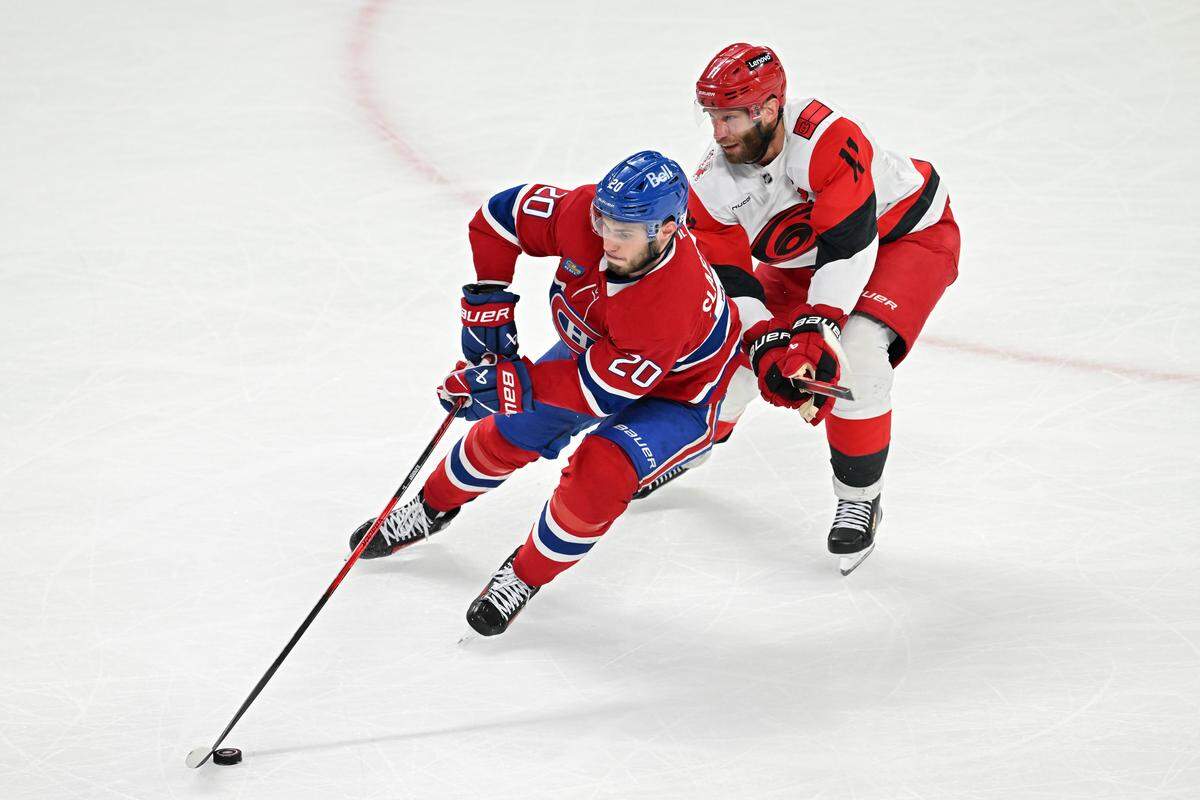 Juraj Slafkovsky #20 of the Montreal Canadiens skates with the puck against Jordan Staal #11 of the Carolina Hurricanes during the third period in Game Four of the Eastern Conference Final of the 2026 Stanley Cup Playoffs at Bell Centre on May 27, 2026 in Montreal, Quebec, Canada. 