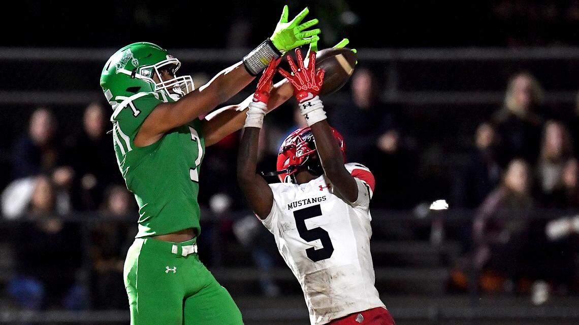 Middle Creek's Derrick Morton (5) attempts the interception against Cary's Jaylin Spivey (7) during the first half. The Cary Imps and the Middle Creek Mustangs met in a conference football game in Cary, N.C. on October 24, 2025