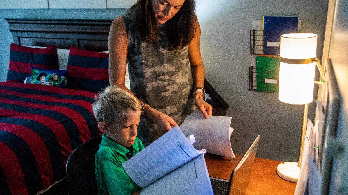 Erin Wall helps her son Carter, a second-grader Penny Road Elementary prepare for a remote learning lesson on Sept. 9, 2020 at their home in Cary. Wake County may bring back the limited use of remote learning days when in-person classes are canceled due to school building closures.