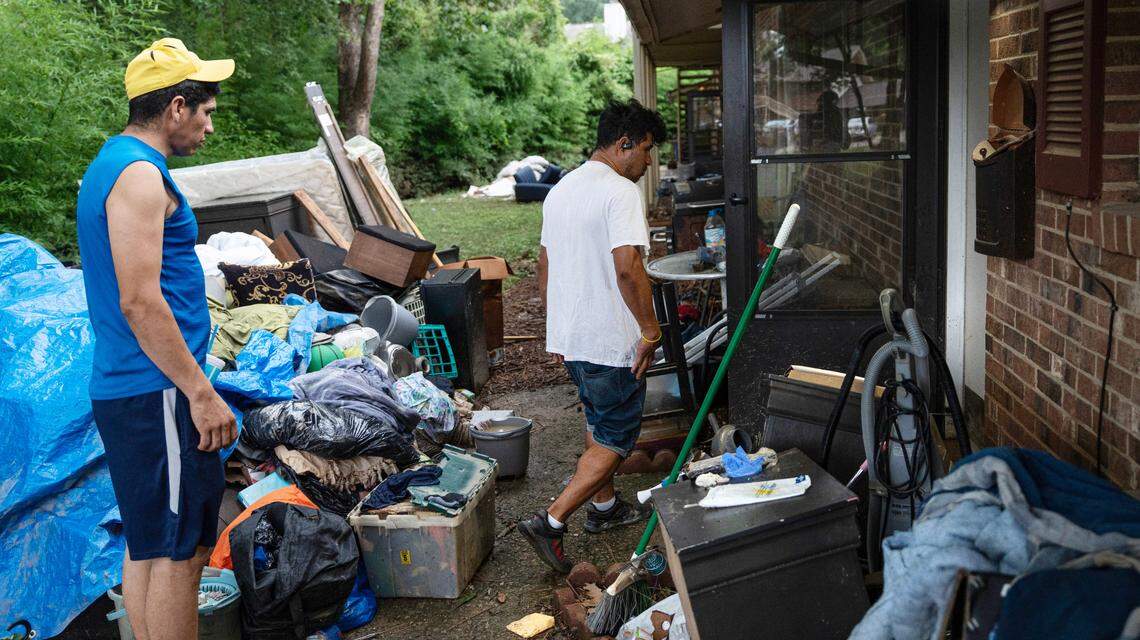 José Martinez and Henry Galón strip drywall and insulation in the Camelot Village apartments on Thursday, July 10, 2025. Severe rains and flooding from Tropical Depression Chantal forced many residents to evacuate, leaving their belongings at the mercy of floodwaters.