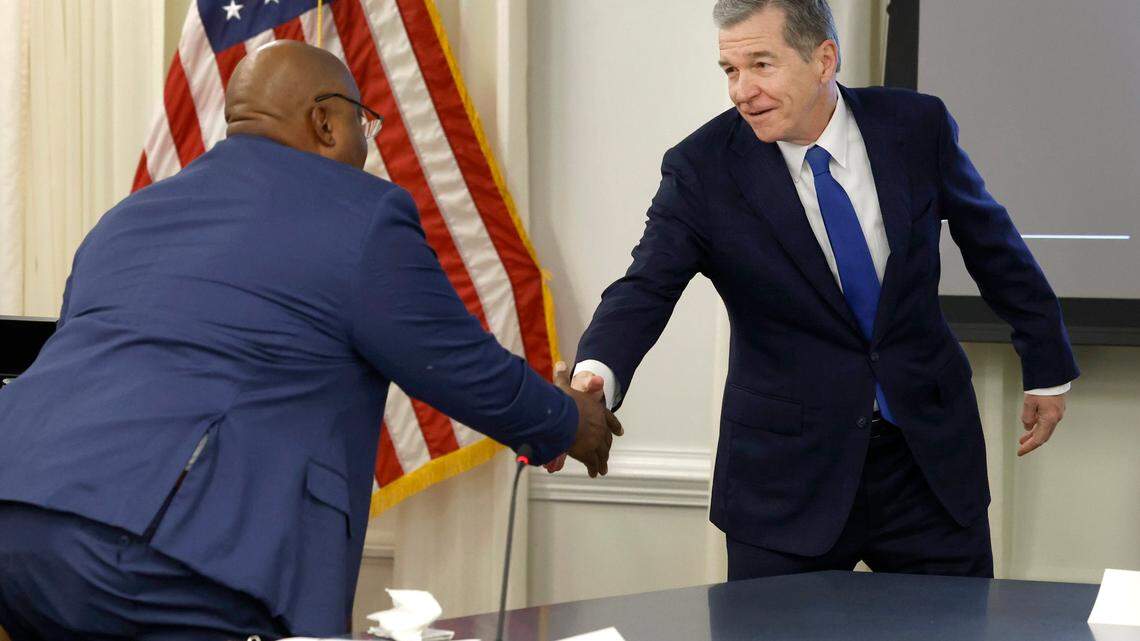North Carolina Gov. Roy Cooper greets Lt. Gov. Mark Robinson before the Council of State meeting in Raleigh, N.C., Tuesday, Jan. 9, 2024.