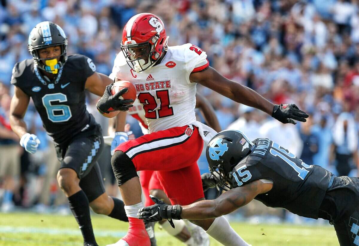 N.C. State running back Matt Dayes (21) beats North Carolina safety Donnie Miles (15) on a 18-yard touchdown run during the first half of the Wolfpack’s game against UNC at Kenan Stadium in Chapel Hill, N.C., Friday, Nov. 25, 2016.
