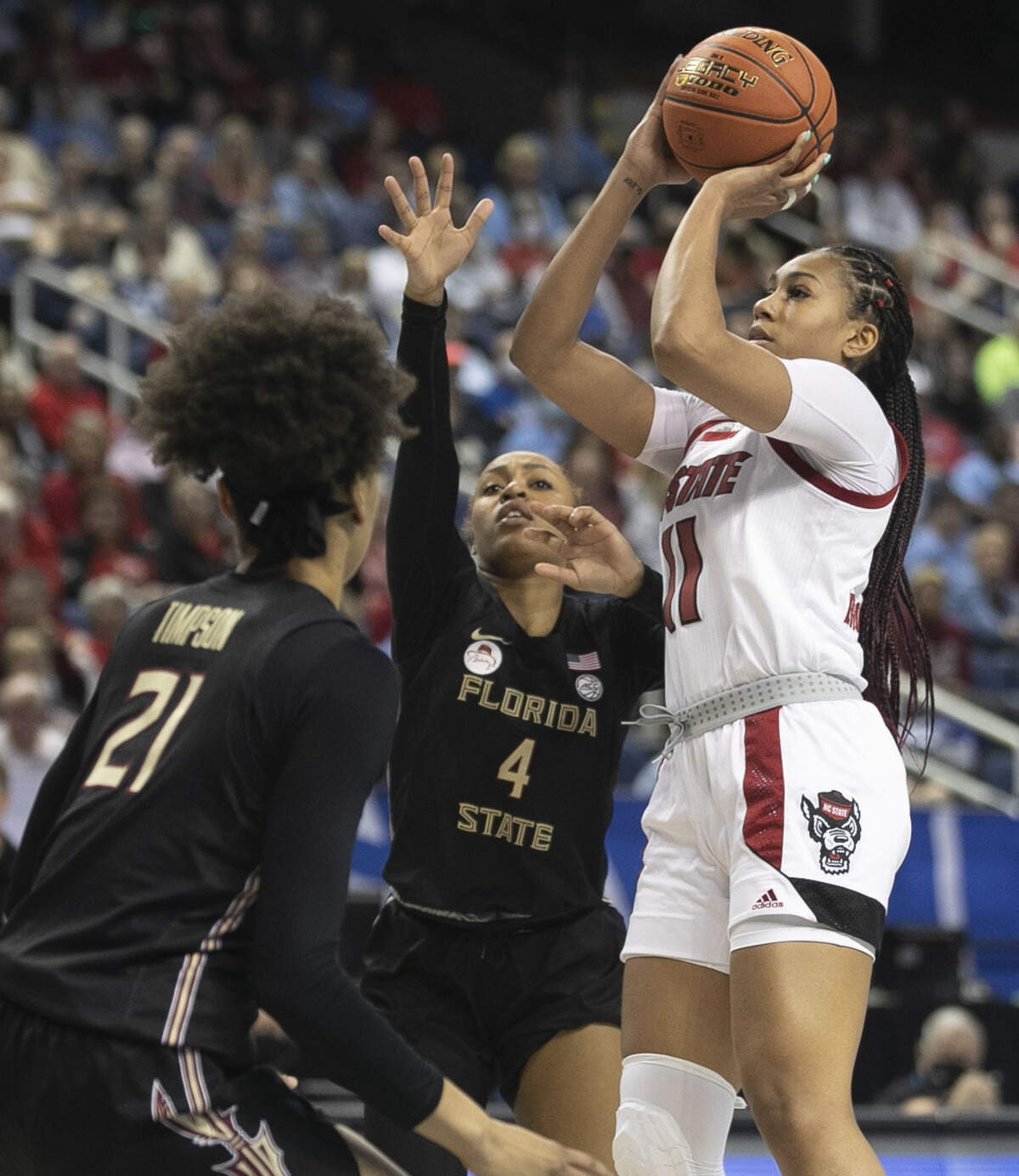 N.C. State’s Jakia Brown-Turner (11) shoots over Florida State’s Sara Bejedi (4) and Makayla Simpson (21) in the second half during the quarterfinal of the ACC Women’s Tournament on Friday, March 4, 2022 at the Greensboro Coliseum in Greensboro, N.C.