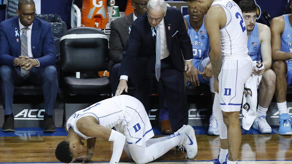 North Carolina head coach Roy Williams checks on Duke's Trevon Duval (1) after he was injured during the first half of UNC's game against Duke.
