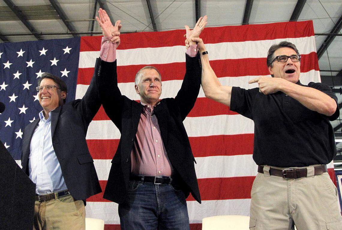 NC Gov. Pat McCrory, left, and Texas Governor Rick Perry, right, show their support for US Senate candidate Thom Tillis, center, as the Republicans hold The Conservative Rally at the Central Marketing Tobacco Warehouse in Smithfield NC on Oct. 24, 2014.