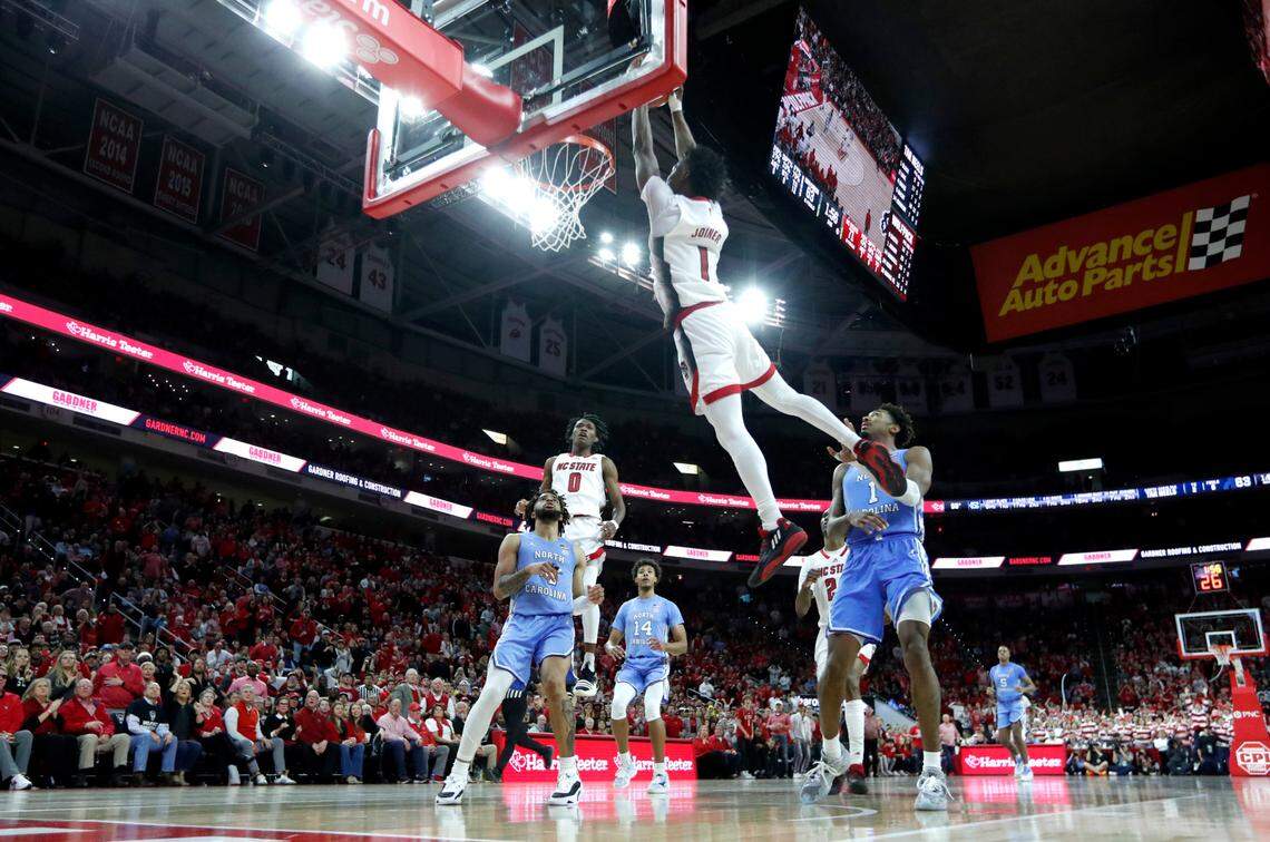 N.C. State’s Jarkel Joiner (1) slams in two on an alley-oop from Terquavion Smith (0) late in the second half of N.C. State’s 77-69 victory over UNC at PNC Arena in Raleigh, N.C., Sunday, Feb. 19, 2023.