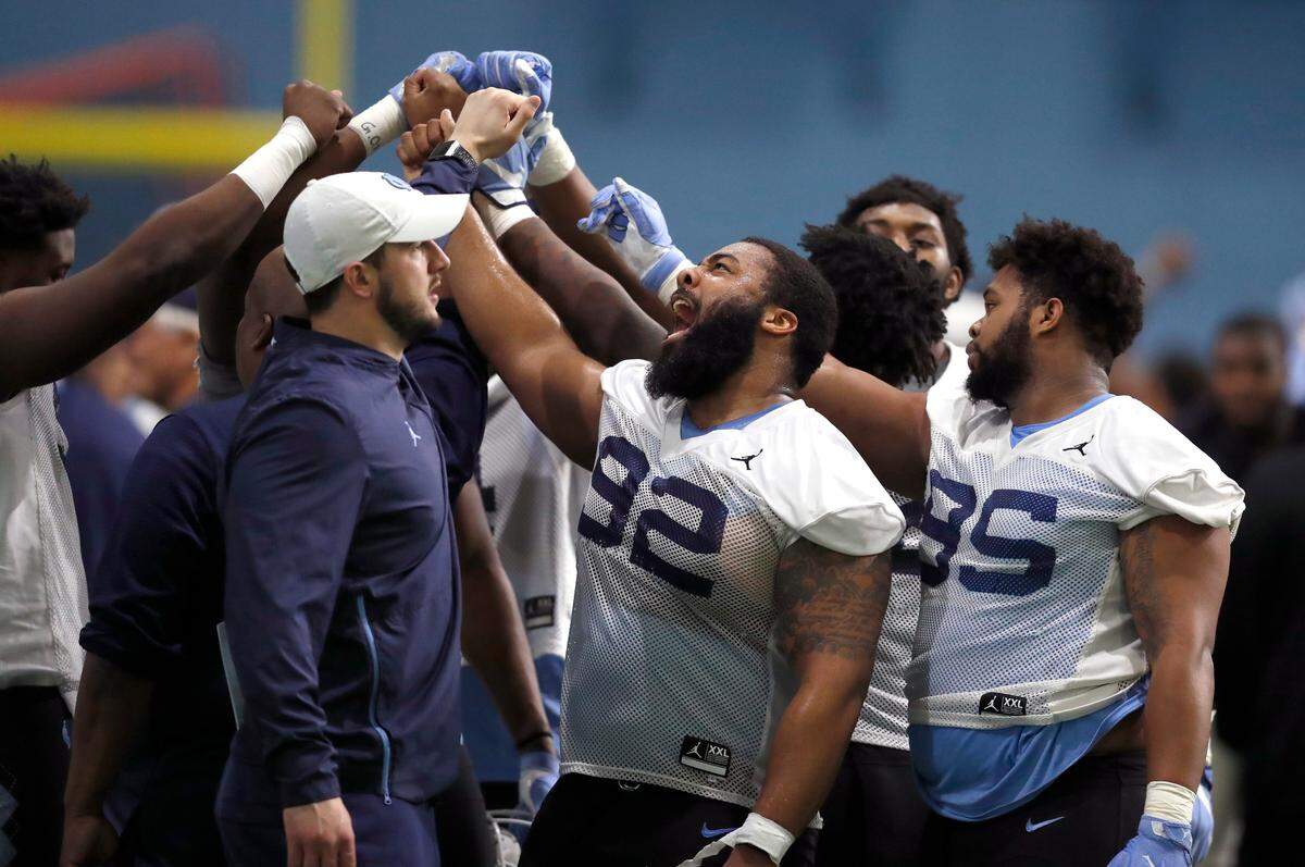 North Carolina defensive tackle Aaron Crawford (92) huddles with fellow defensive linemen during UNC’s first spring football practice in Chapel Hill, N.C., Sunday, March 3, 2019.
