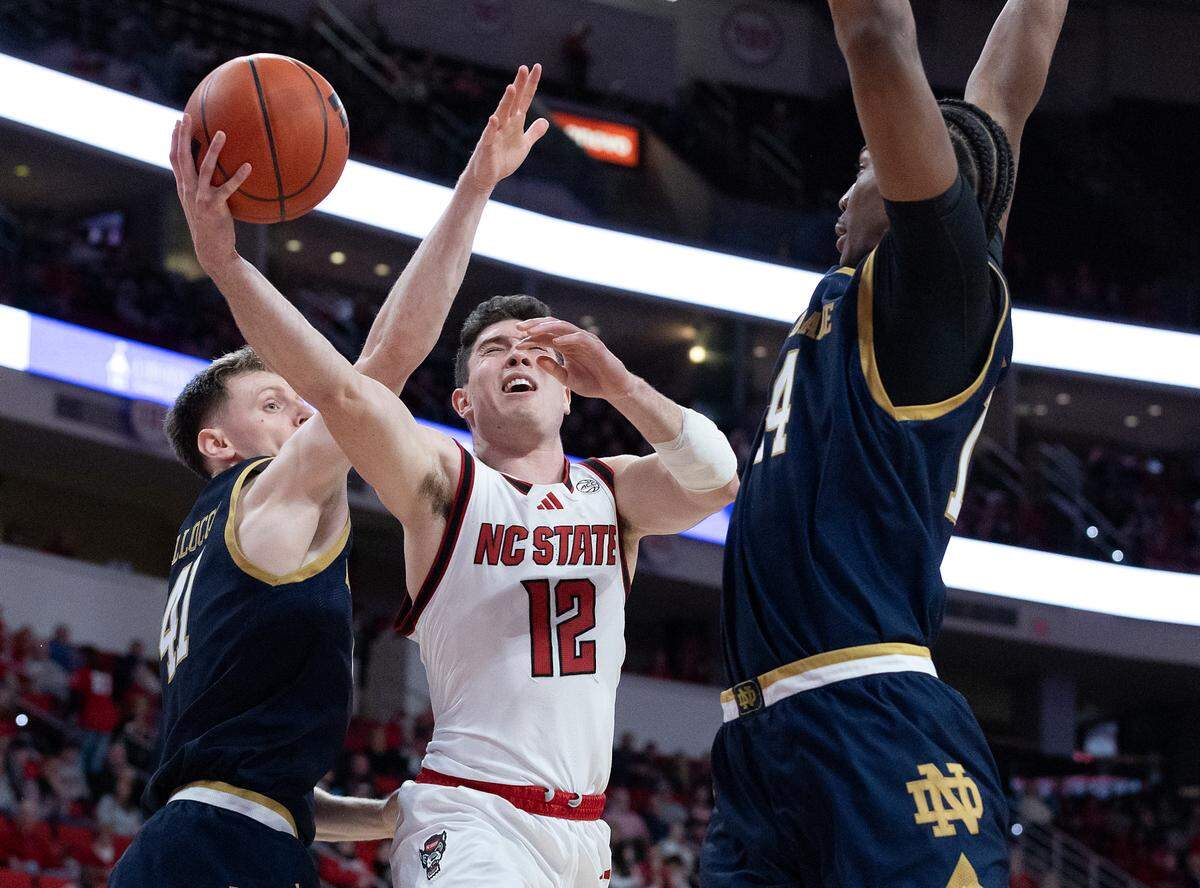 N.C. State’s Michael O’Connell drives to the basket between Notre Dame’s Matt Allocco and Kebba Njie during the first half of the Wolfpack’s game on Wednesday, Jan. 8, 2025, at Lenovo Center in Raleigh, N.C.