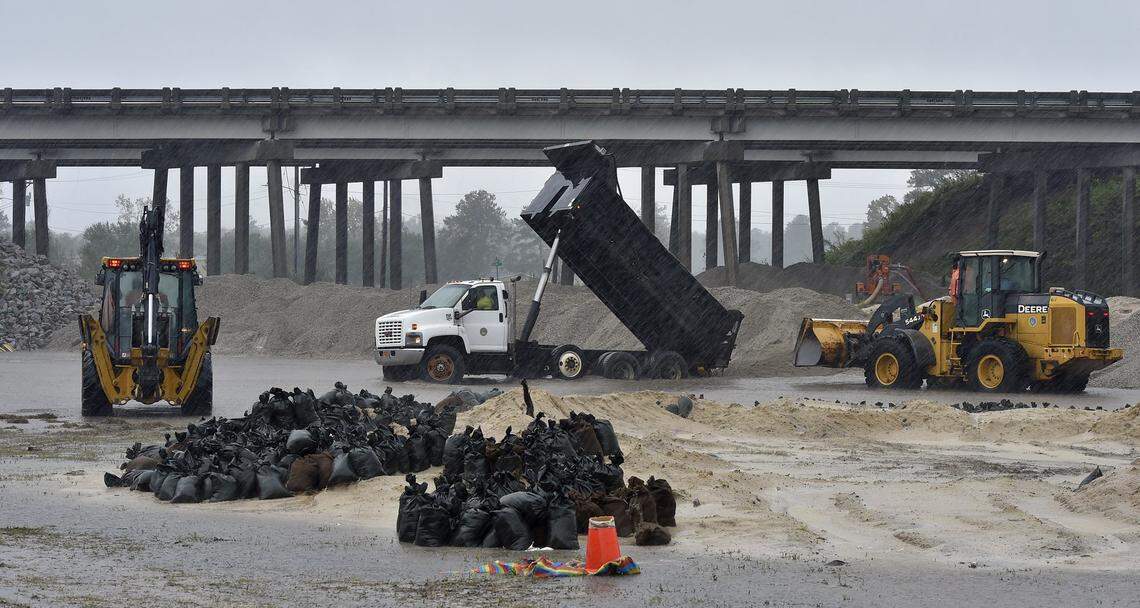 As torrential rain from Tropical Storm Florence continued to fall Saturday evening in Lumberton, NC, workers continue to reinforce a levee near an overpass and railroad crossing, as river and flood water levels continue to rise.