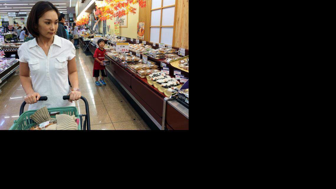 Tomoka Yamanishi moves through a grocery in Tokyo after buying a package of Silky Pork. She has since returned to buy more.

