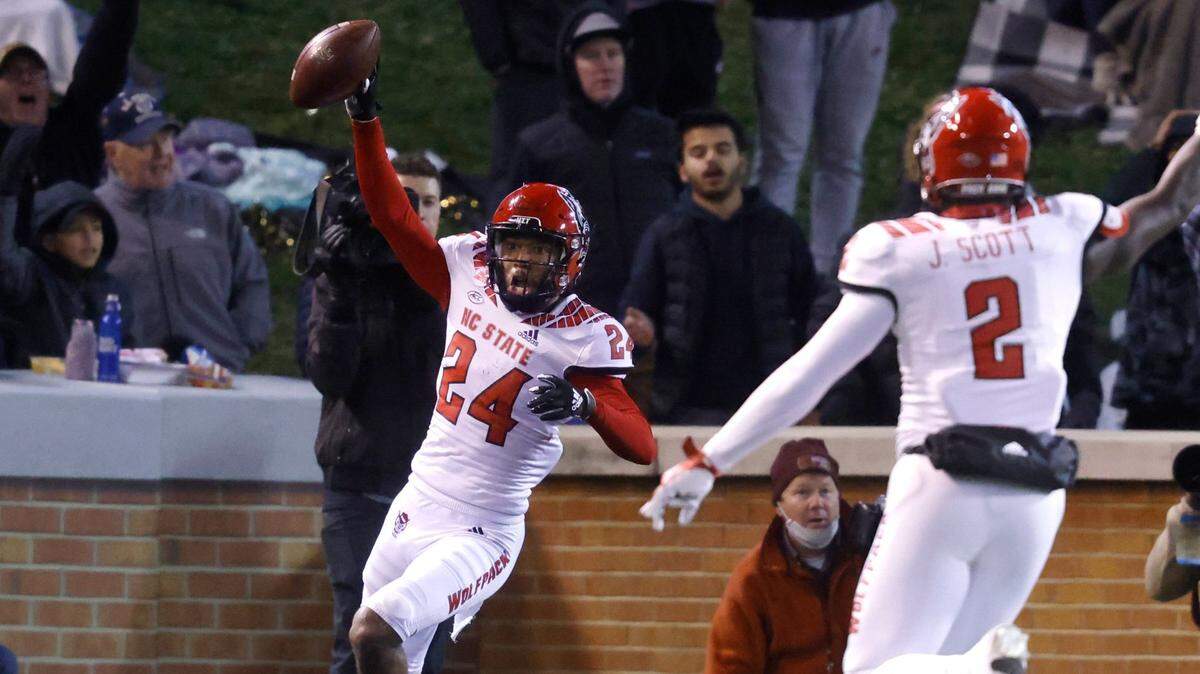N.C. State cornerback Derrek Pitts Jr. (24) celebrates intercepting the ball with Jaylon Scott (2) during the second half of Wake Forest’s 45-42 victory over N.C. State at Truist Field in Winston-Salem, N.C., Saturday, November 13, 2021.