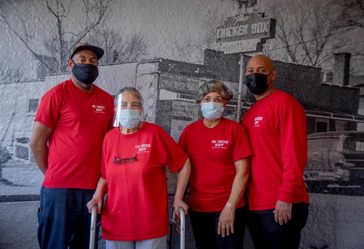 From left, Jeff Johnson, Betsy Johnson, Ruth Dash, and Tre Tapp stand for a portrait together in front of an old photograph of the original location of their familyÕs restaurant, the Chicken Hut, founded in 1957 by TappÕs late parents Claiborne Tapp Jr., and Peggy Tapp, on Thursday, Feb. 4, 2021, in Durham, N.C.