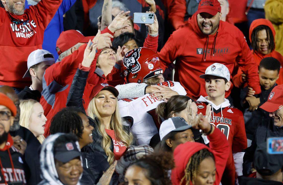 N.C. State quarterback Ben Finley (10) heads into the stands to celebrate after N.C. State’s 30-27 overtime victory over UNC at Kenan Stadium in Chapel Hill, N.C., Friday, Nov. 25, 2022.