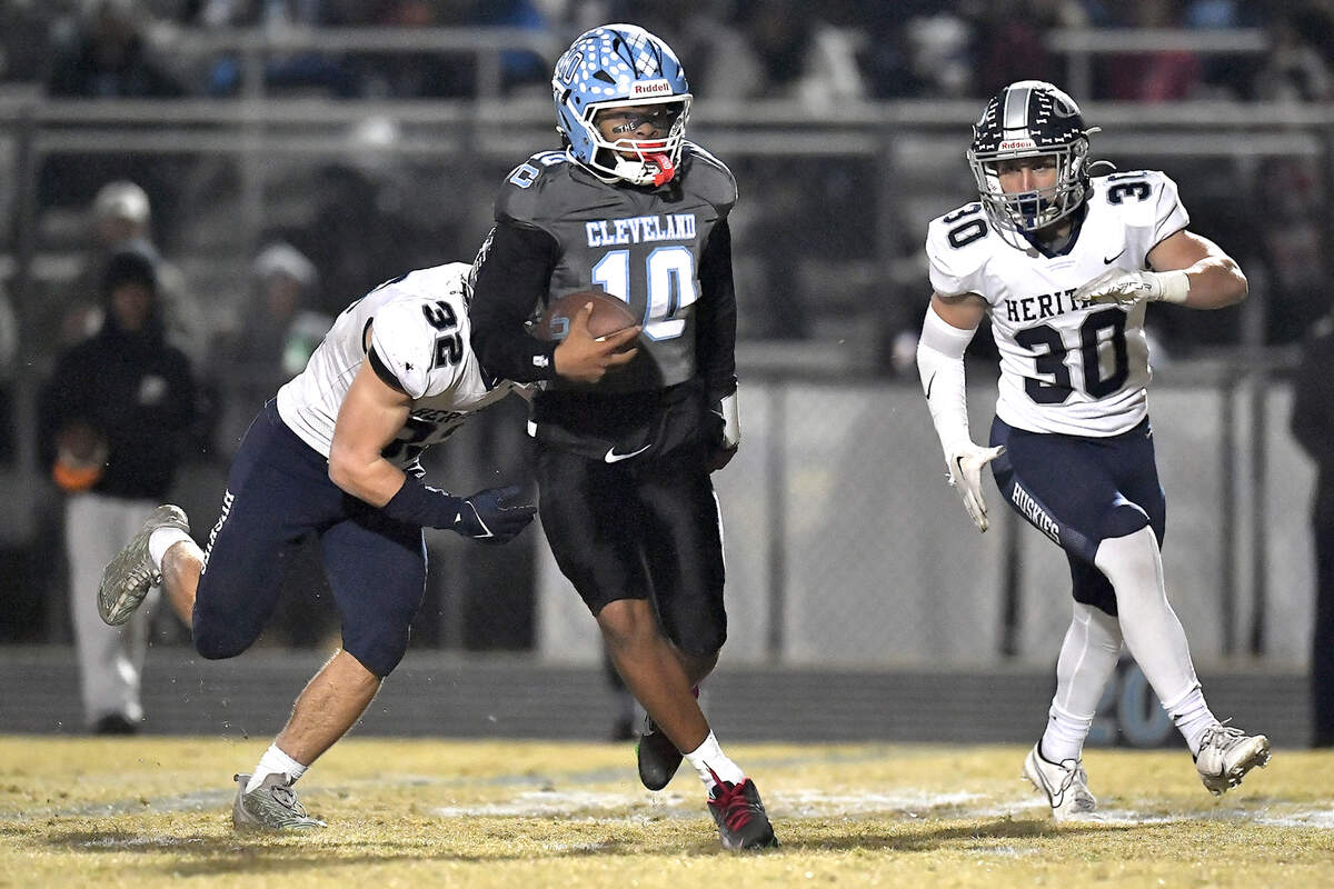 Heritage quarterback Jackson Byrd (10) runs for yards in the second half ahead of Heritage’s Zane Kirsch (30) and Seth Rucker (32) in the second half. The Cleveland Rams and the Heritage Huskies met in the first round of the NCHSAA 4A playoffs in Clayton, N.C. on November 15, 2024.