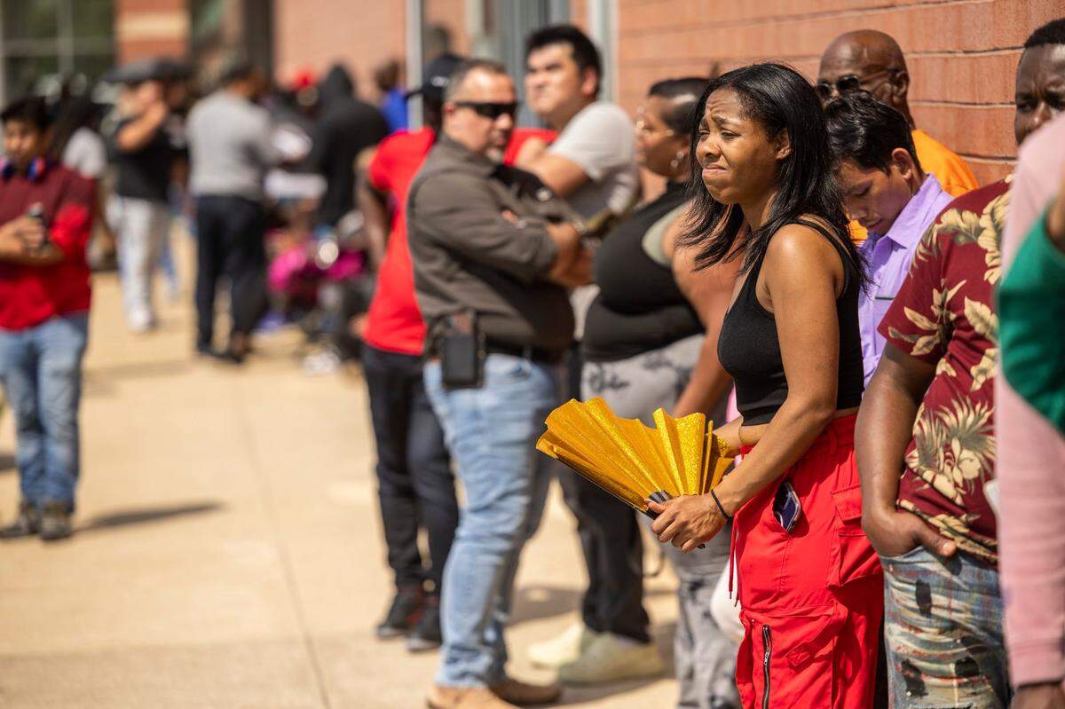 Leeza Wimbish of Raleigh, fans herself while waiting with dozens of people for hours outside the DMV office on New Bern Avenue in Raleigh on April 22, 2025.