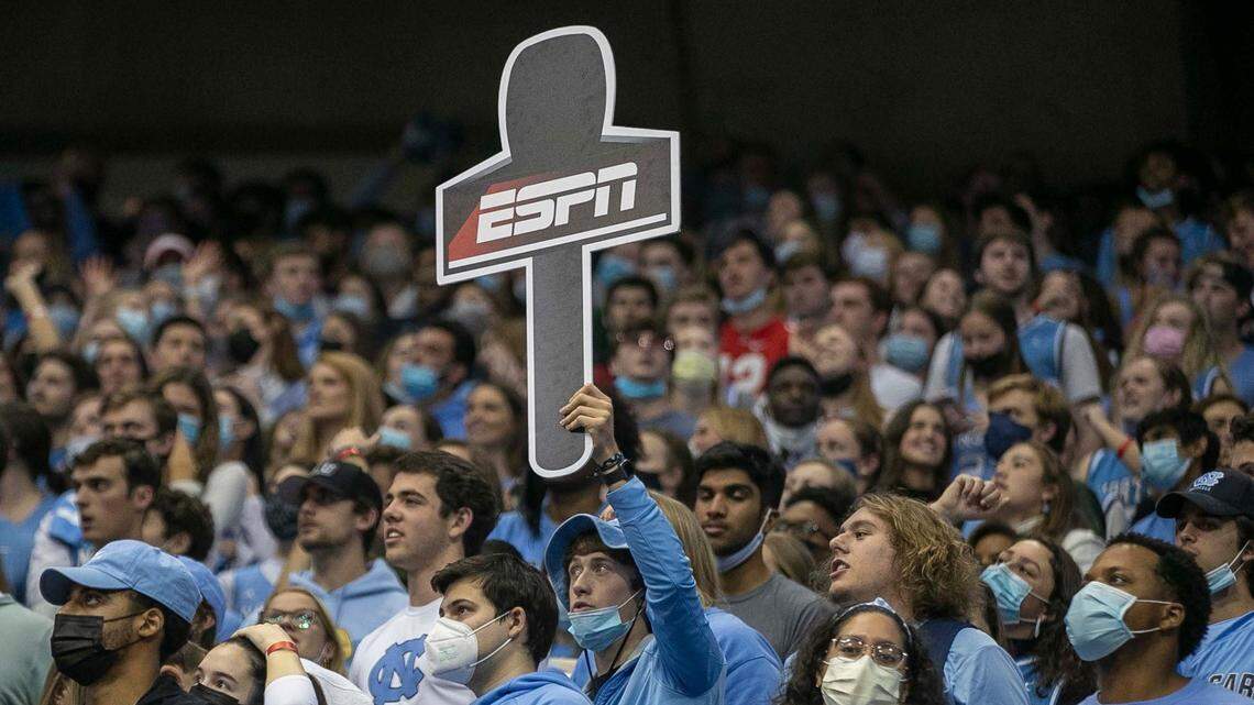 A fan in the North Carolina student section hoists an ESPN microphone in honor of Dick Vitale, who was introduced to the crowd before calling the North Carolina vs. Michigan game on Wednesday, December 1, 2021 at the Smith Center in Chapel Hill, N.C.