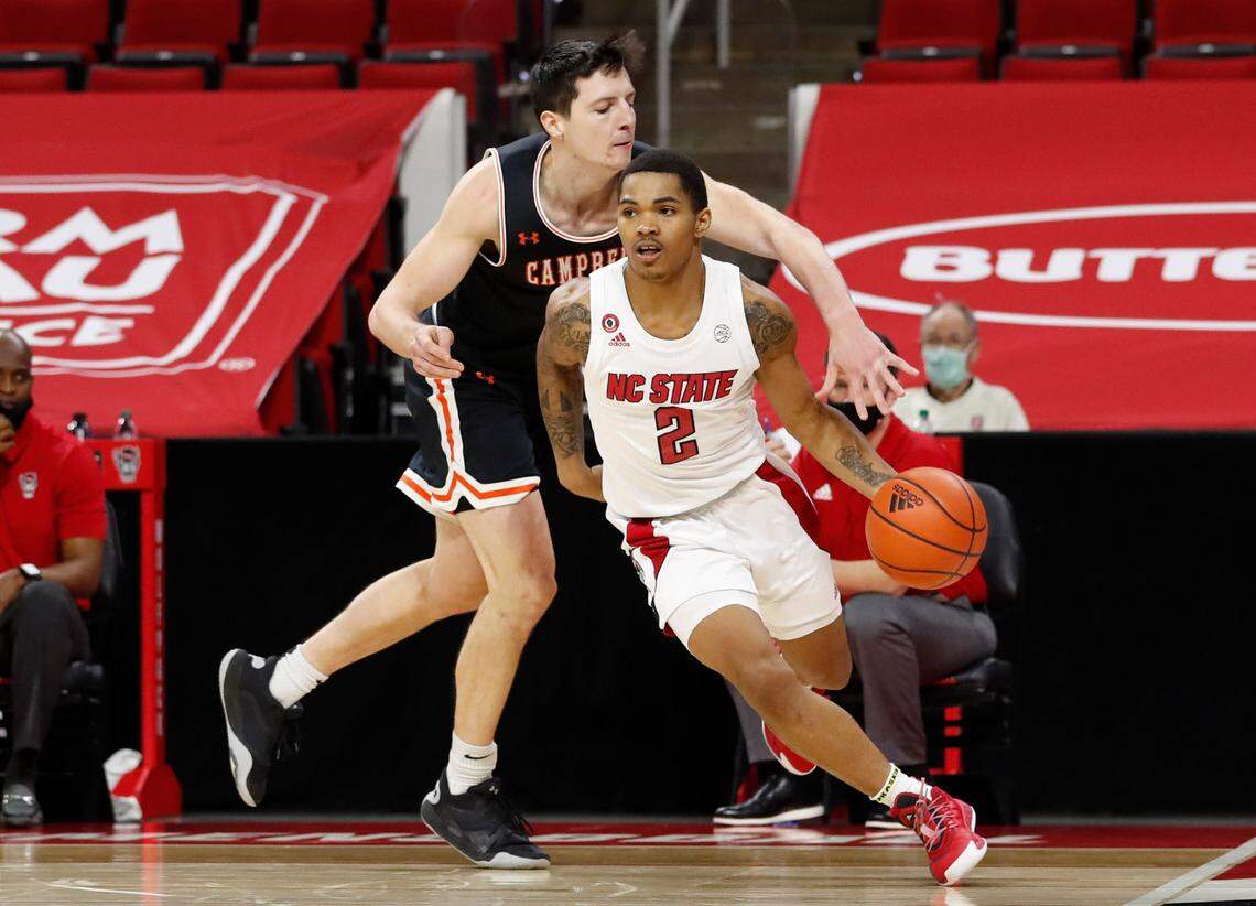N.C. State’s Shakeel Moore (2) drives past Campbell’s Jesus Carralero (12) during the second half of N.C. State’s 69-50 victory over Campbell at PNC Arena in Raleigh, N.C., Saturday, Dec. 19, 2020.