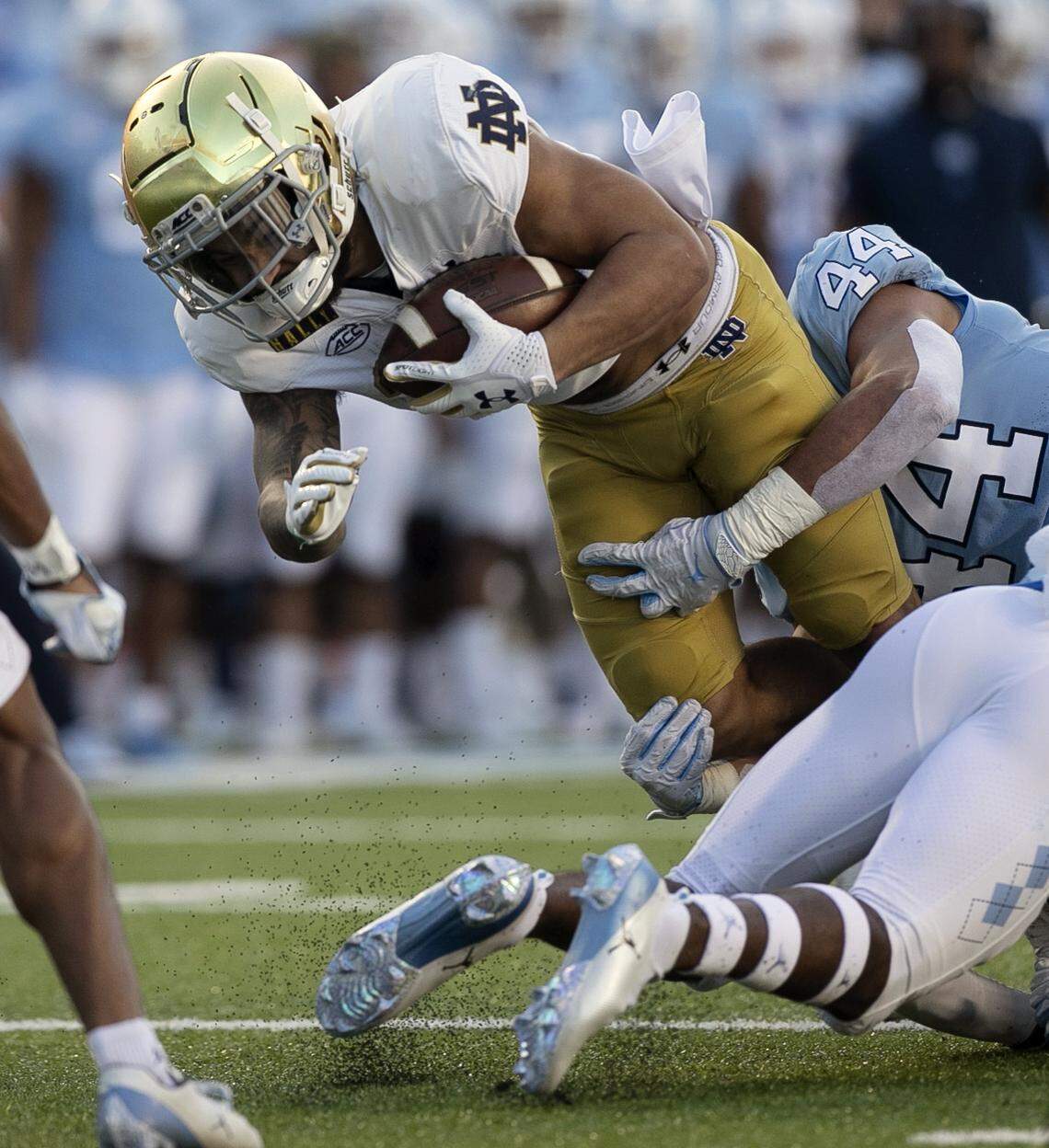 North Carolina’s Jeremiah Gemmell (44) stops Notre Dame’s Kyren Williams (23) after a five yard gain to set up a Notre Dame touchdown in the first quarter on Friday, November 27, 2020 at Kenan Stadium in Chapel Hill, N.C.