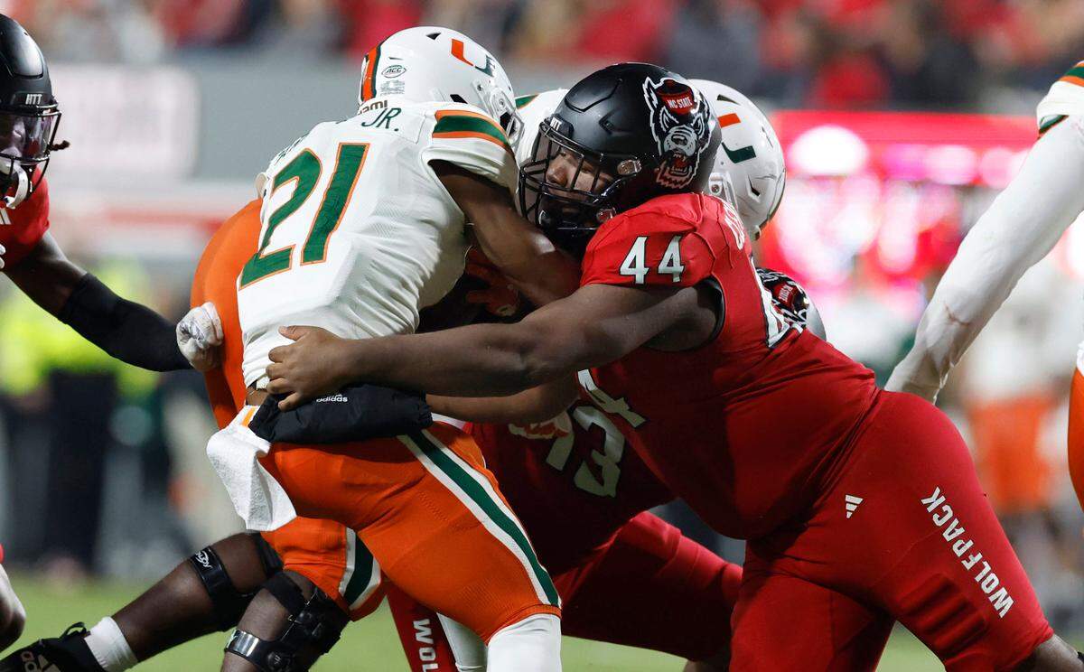 N.C. State defensive lineman Brandon Cleveland (44) stops Miami running back Henry Parrish Jr. (21) during the first half of N.C. State’s game against Miami at Carter-Finley Stadium in Raleigh, N.C., Saturday, Nov. 4, 2023.