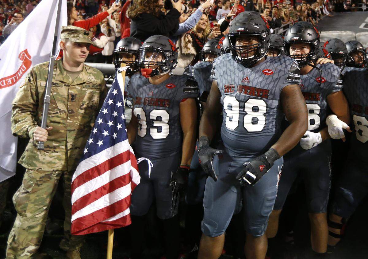 N.C. State’s Brady Bodine (33) gets ready to run out onto the field with the American flag before the Wolfpack’s game against Florida State at Carter-Finley Stadium Saturday, Nov. 5, 2016. N.C. State defensive tackle B.J. Hill (98) is to the right.