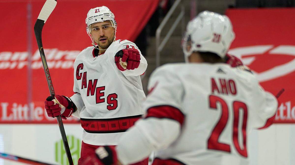 Carolina Hurricanes right wing Nino Niederreiter (21) celebrates his goal with Sebastian Aho (20) in the third period of an NHL hockey game against the Detroit Red Wings, Sunday, March 14, 2021, in Detroit. (AP Photo/Paul Sancya)