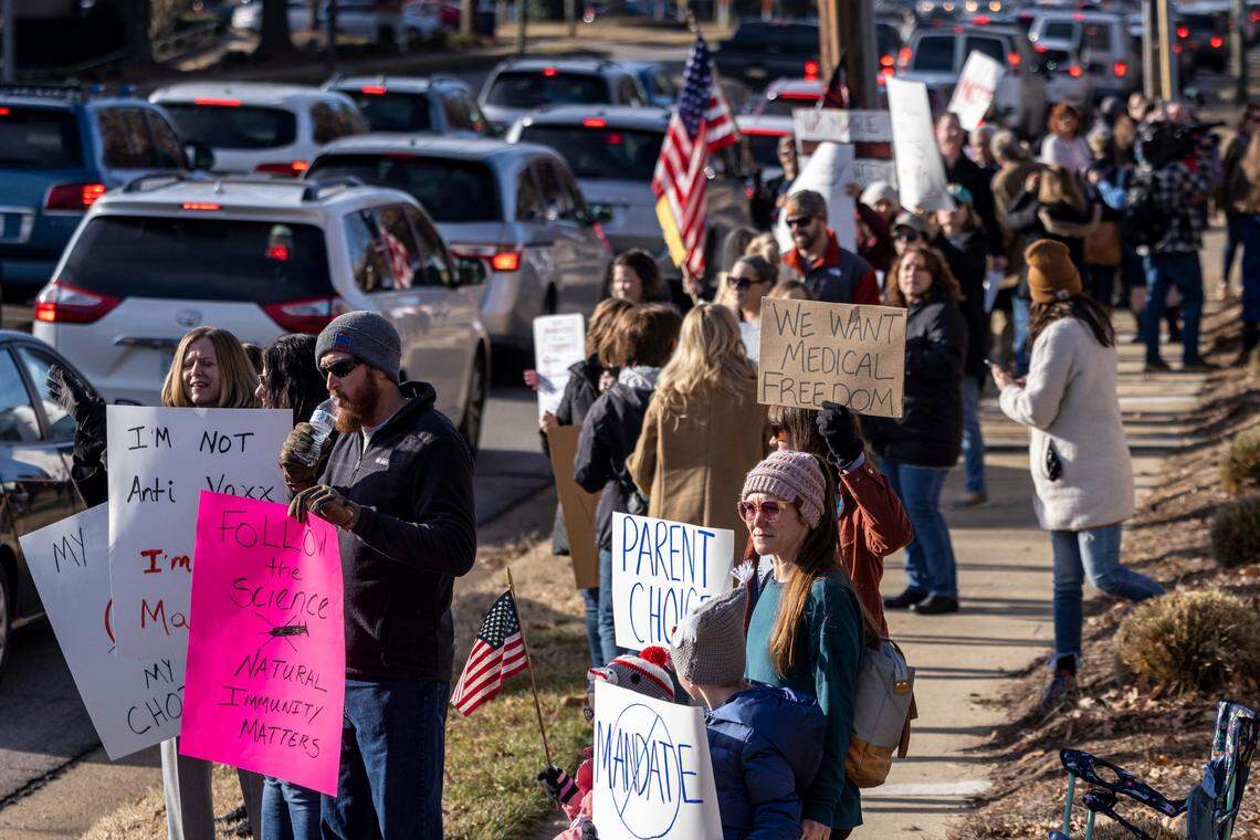 Demonstrators opposed to vaccine requirements protest outside the The N.C. Commission for Public Health in Raleigh Wednesday, Feb. 2, 2022. The commission unanimously voted against a rule-making petition from four UNC System professors to add the COVID vaccine to state immunization requirements for people who are 17 years old or who are entering 12th grade as of July 1.