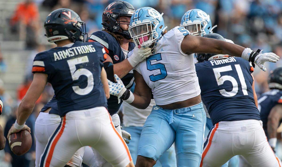 North Carolina defensive lineman Travis Shaw (5) pressures Virginia quarterback Brennan Armstrong (5) in the fourth quarter on Saturday, November 5, 2022 at Scott Stadium in Charlottesville, Va.