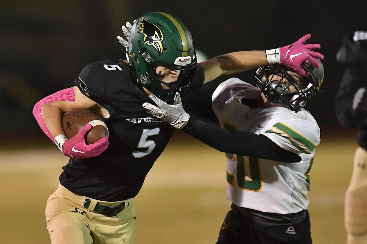 Ravenscroft’s AJ Peterson (5) stiff-arms Harrells Christian’s Connor Casteen (20) during the first half. The Ravenscroft Ravens and the Harrells Christian Crusaders met in a football game in Raleigh, N.C. on October 21, 2022.