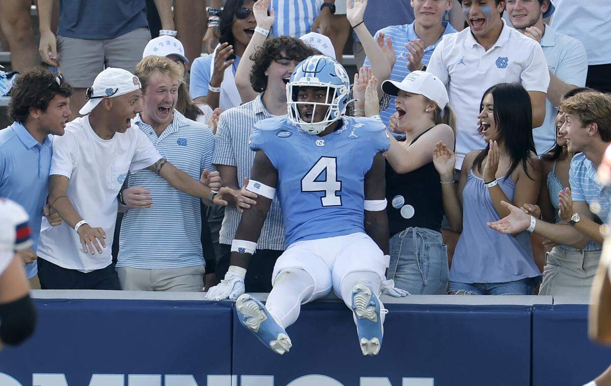 North Carolina linebacker Mikai Gbayor (4) jumps into the stands after scoring on a 61-yard fumble return during the second half of UNC’s 41-6 victory over Richmond at Kenan Stadium in Chapel Hill, N.C., Saturday, Sept. 13, 2025.