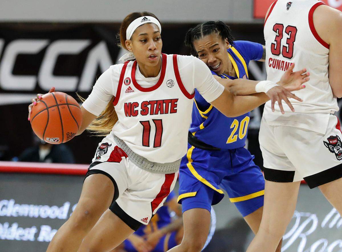 N.C. State’s Jakia Brown-Turner (11) drives around Pittsburgh’s Jayla Everett (20) during the first half of N.C. State’s game against Pittsburgh at Reynolds Coliseum in Raleigh, N.C., Thursday, February 25, 2021.