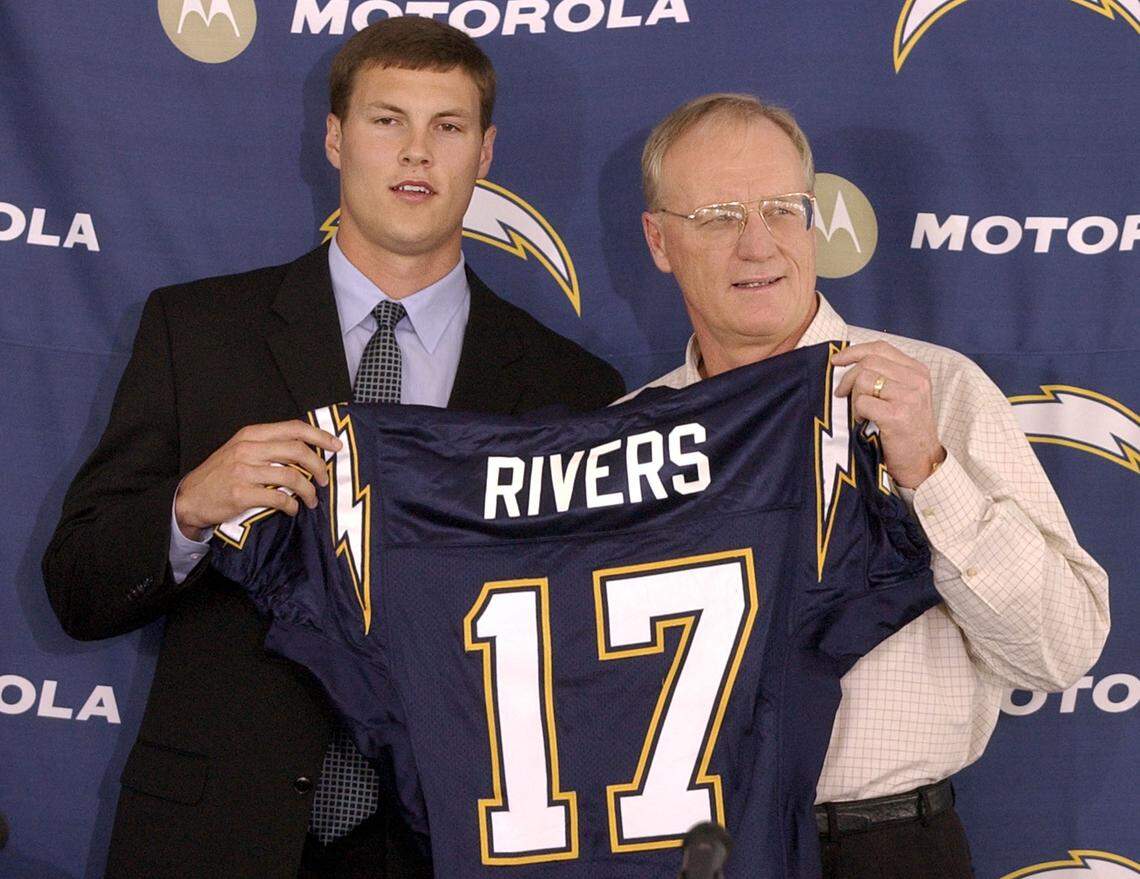 San Diego Chargers quarterback Philip Rivers, left, holds up his Chargers jersey with coach Marty Schottenheimer at a news conference in San Diego, Sunday, April 25, 2004. The Chargers traded No.1 draft pick Eli Manning to the New York Giants for Rivers and future draft picks.