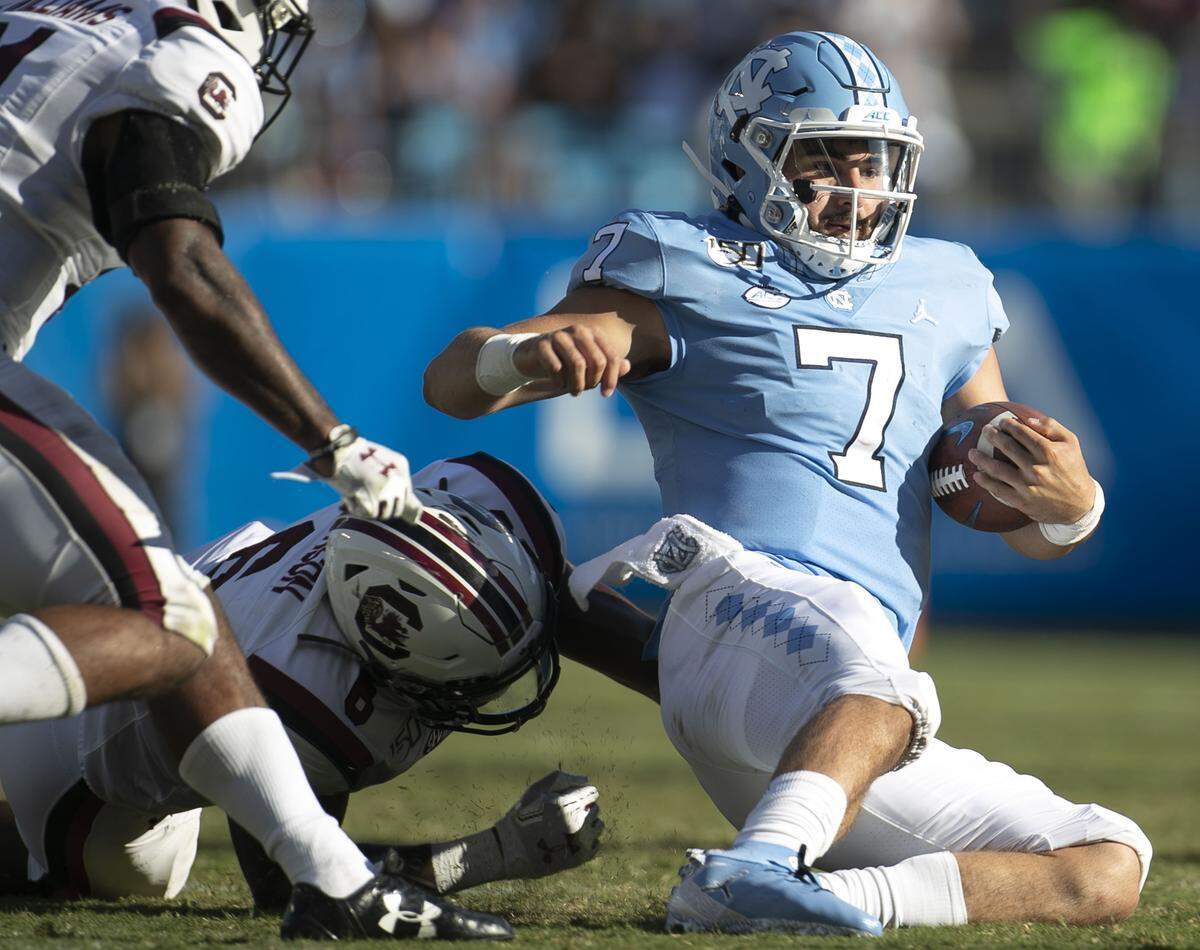 North Carolina quarterback Sam Howell (7) slides to the turf after rushing for seven yards in the third quarter against South Carolina at Bank of America Stadium on Saturday, August 31, 2019 in Charlotte, N.C. Howell rushed for 30 yards and passed for 245 in the Tar Heels’ 24-20 victory.